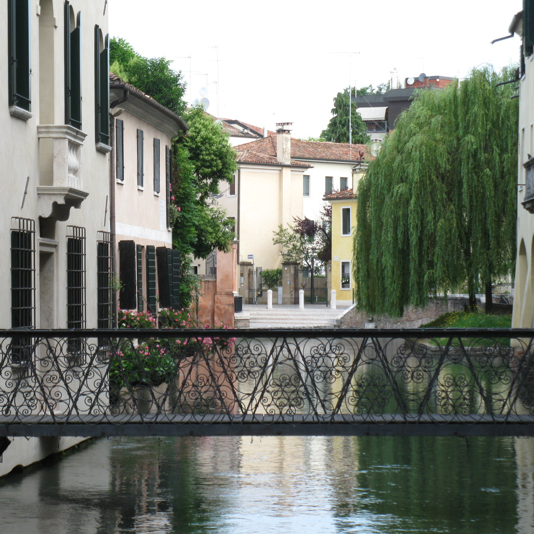 Eine schmale Brücke, von Haus zu Haus über ein Flüsschen. Romantisch fließt es unter einem